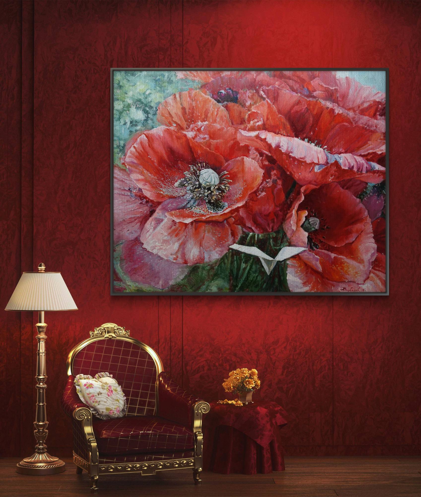 Floral painting on a red wall above a decorative chair with a lamp and small table.