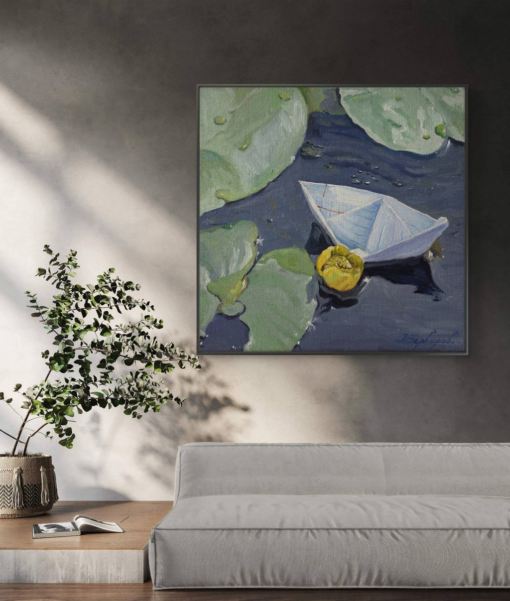 Framed painting of a paper boat and lily pad on a wall in a living room.