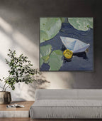 Framed painting of a paper boat and lily pad on a wall in a living room.