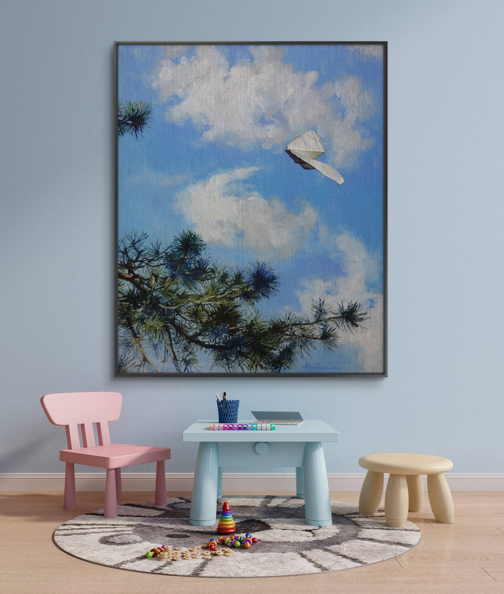 Children's playroom with a large framed painting of a tree and airplane, pink chair, light blue table, and wooden stool.