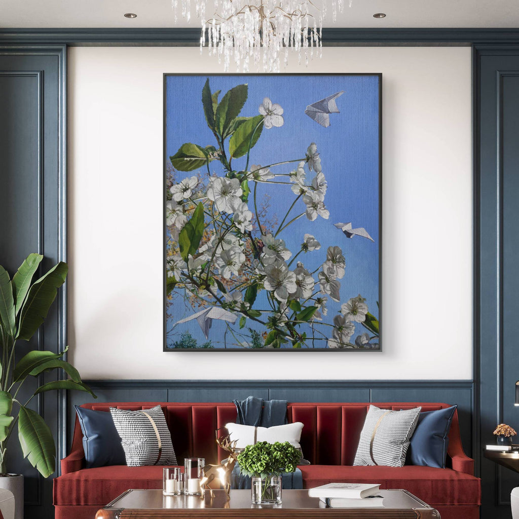 Framed floral artwork on a wall above a red sofa with decorative pillows.