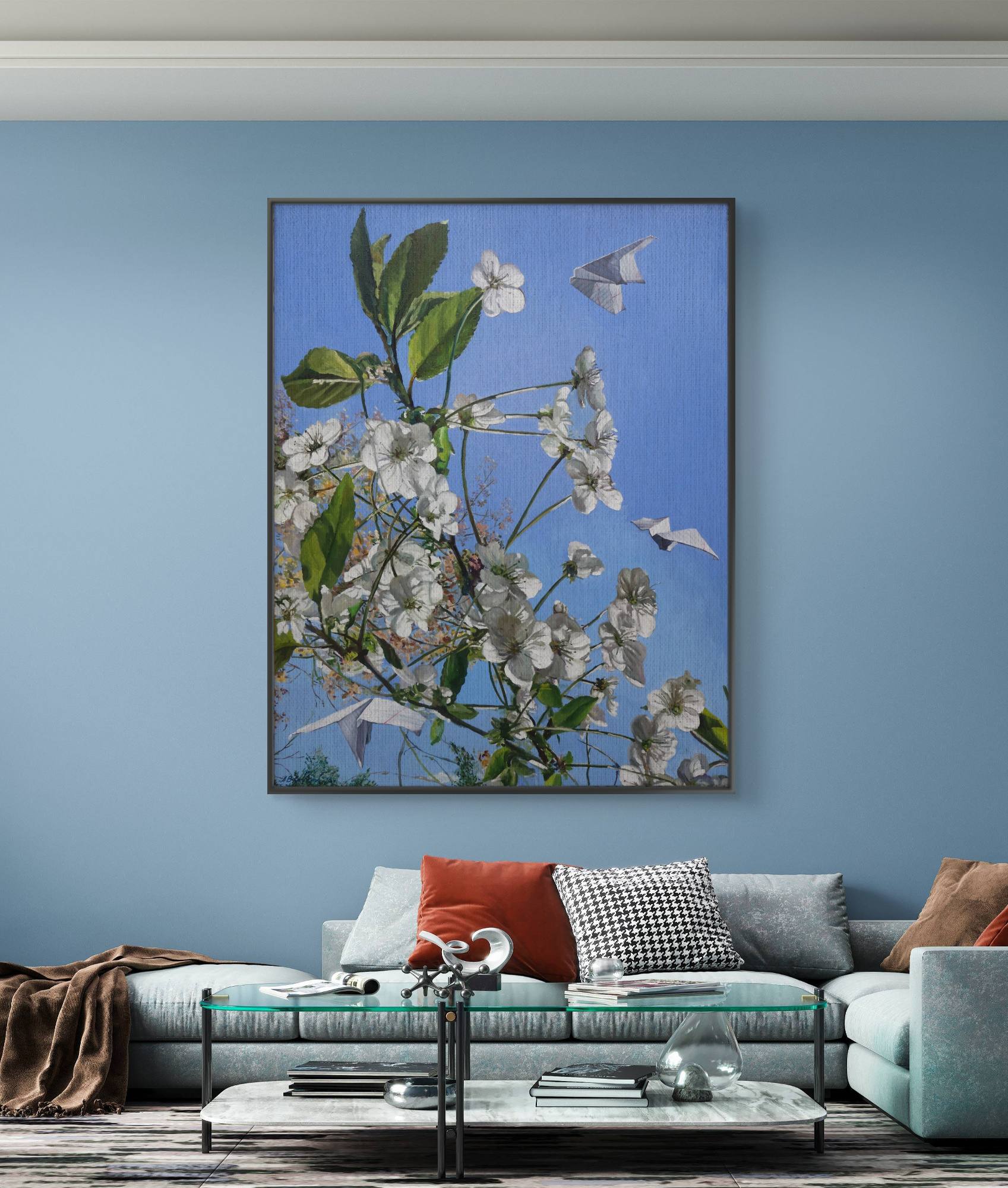 Framed floral artwork on a blue wall above a sofa with colorful cushions.