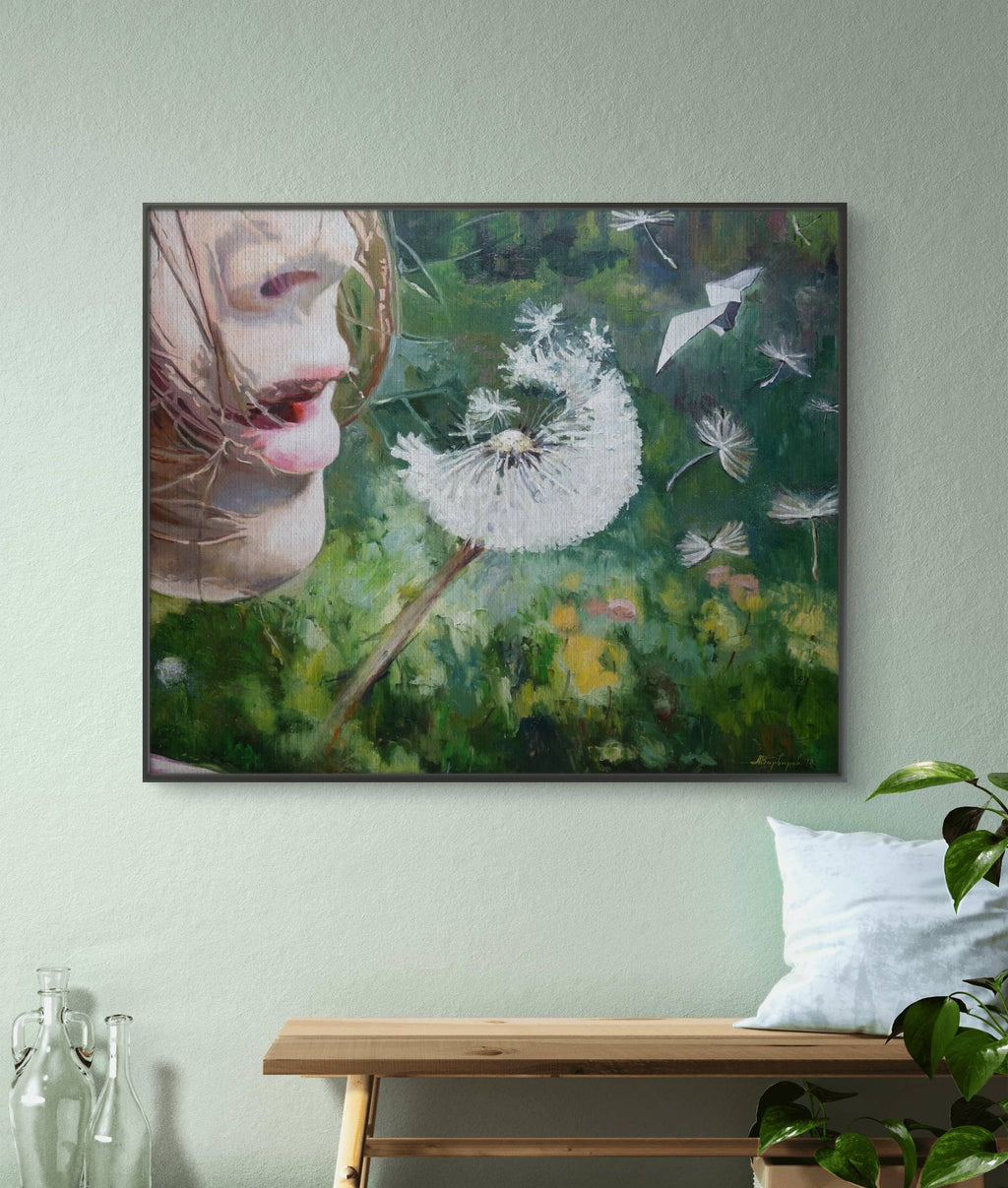 Framed artwork of a woman's face with a dandelion on a light green wall.