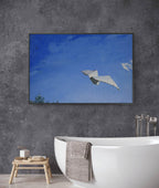 Bathroom with a large framed artwork of a bird flying against a blue sky.