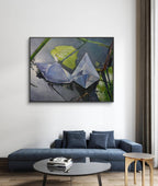 Framed artwork of a blue umbrella and green leaves on a wall above a blue sofa.