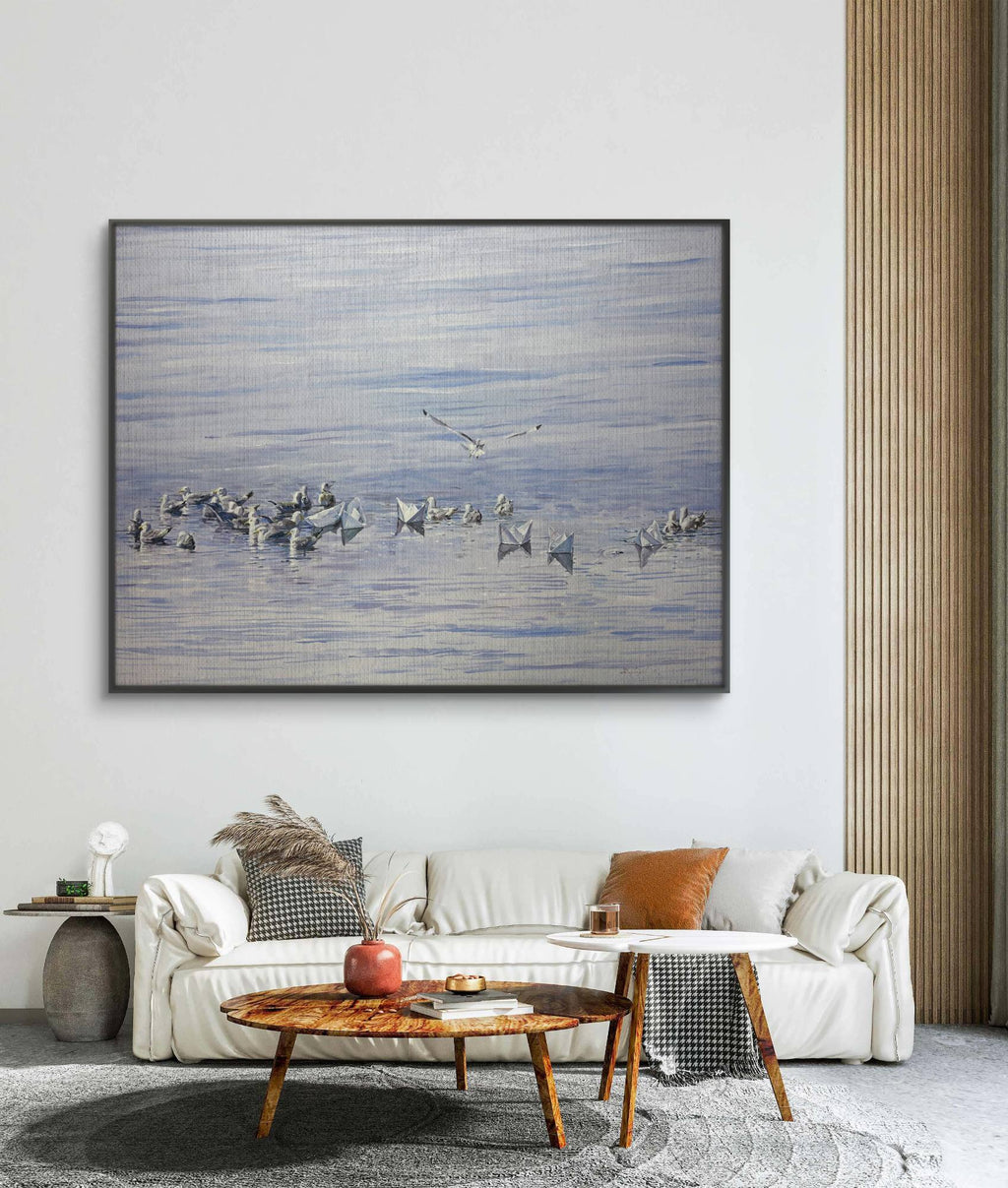 Framed artwork of birds over water in a living room setting with a sofa and coffee table.