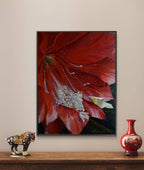 Framed artwork of a red flower on a wall with decorative items below.