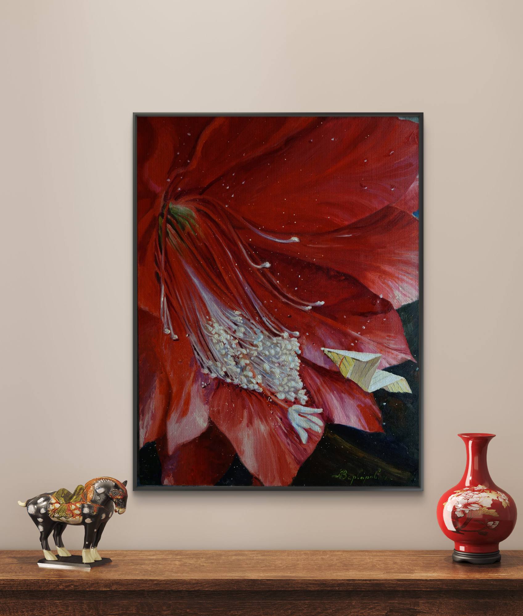 Framed artwork of a red flower on a wall with decorative items below.