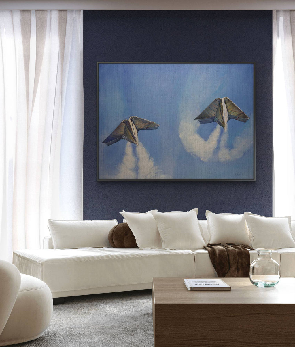Modern living room with a white sofa, wooden coffee table, and a framed artwork of two birds on a blue background.