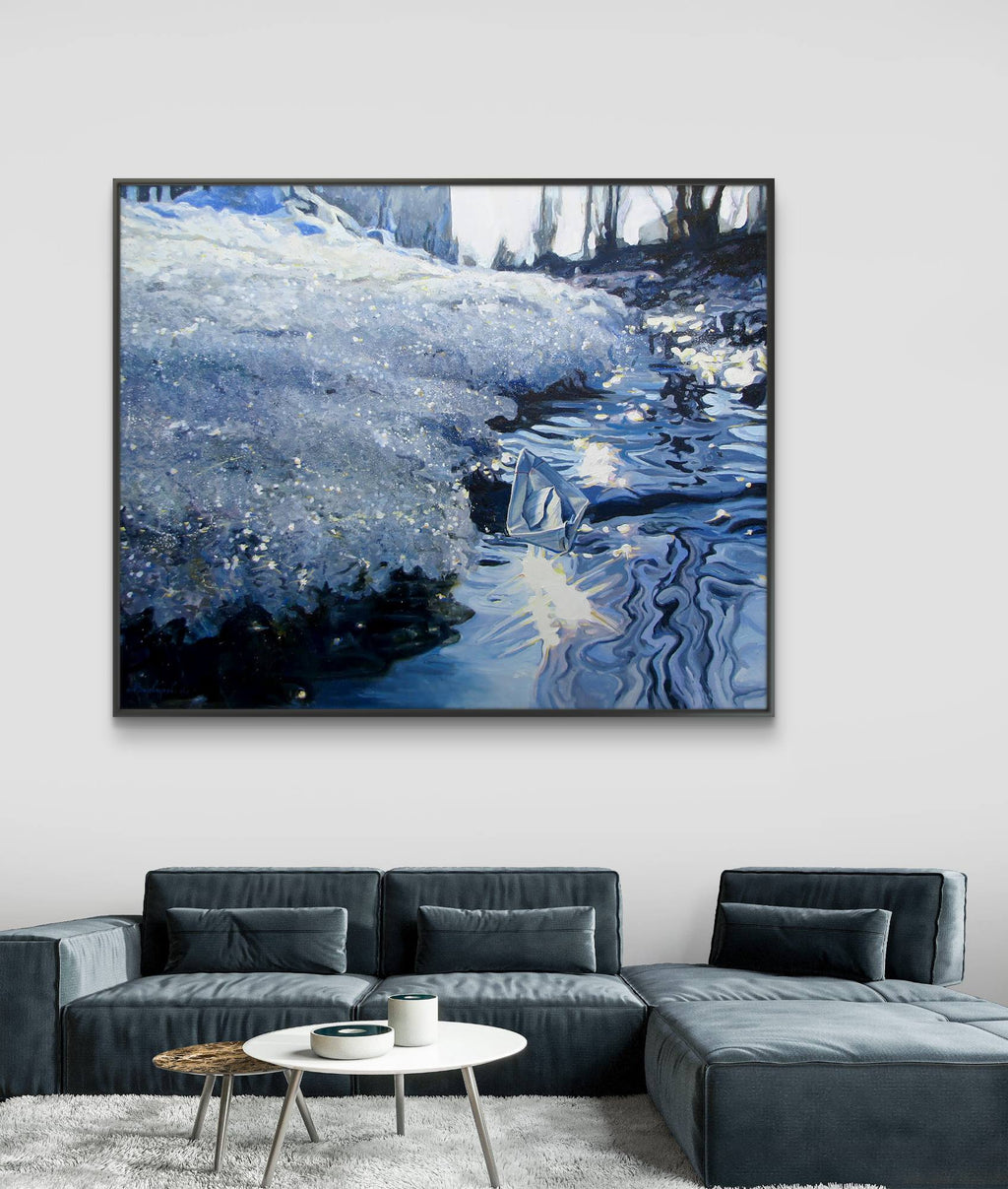 Framed artwork of a snowy landscape above a gray sectional sofa in a living room.