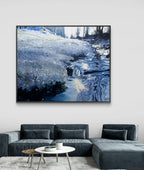 Framed artwork of a snowy landscape above a gray sectional sofa in a living room.