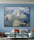 Bedroom with a large framed painting of a paper airplane over mountains, a white sofa with colorful cushions, and a coffee table.