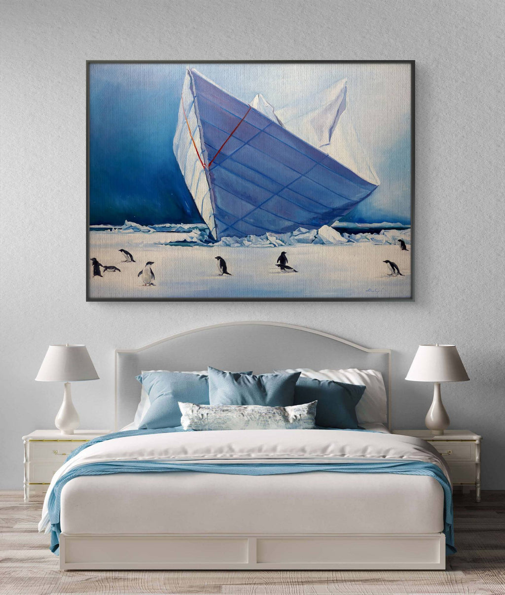 Framed artwork of a sailboat and penguins on an iceberg above a bed with matching decor.