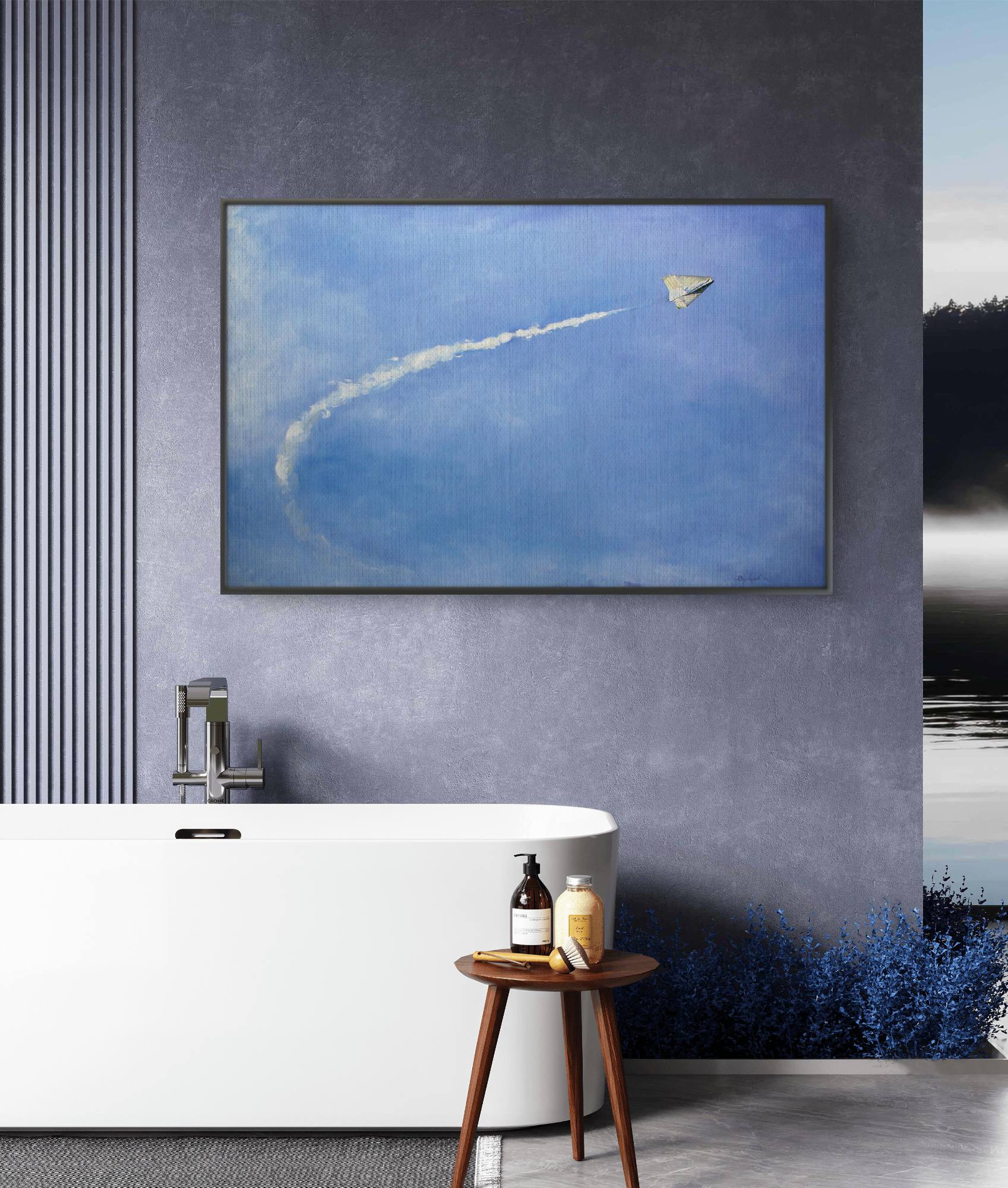 Framed artwork of a kite flying in the sky above a modern bathroom with a bathtub and stool.