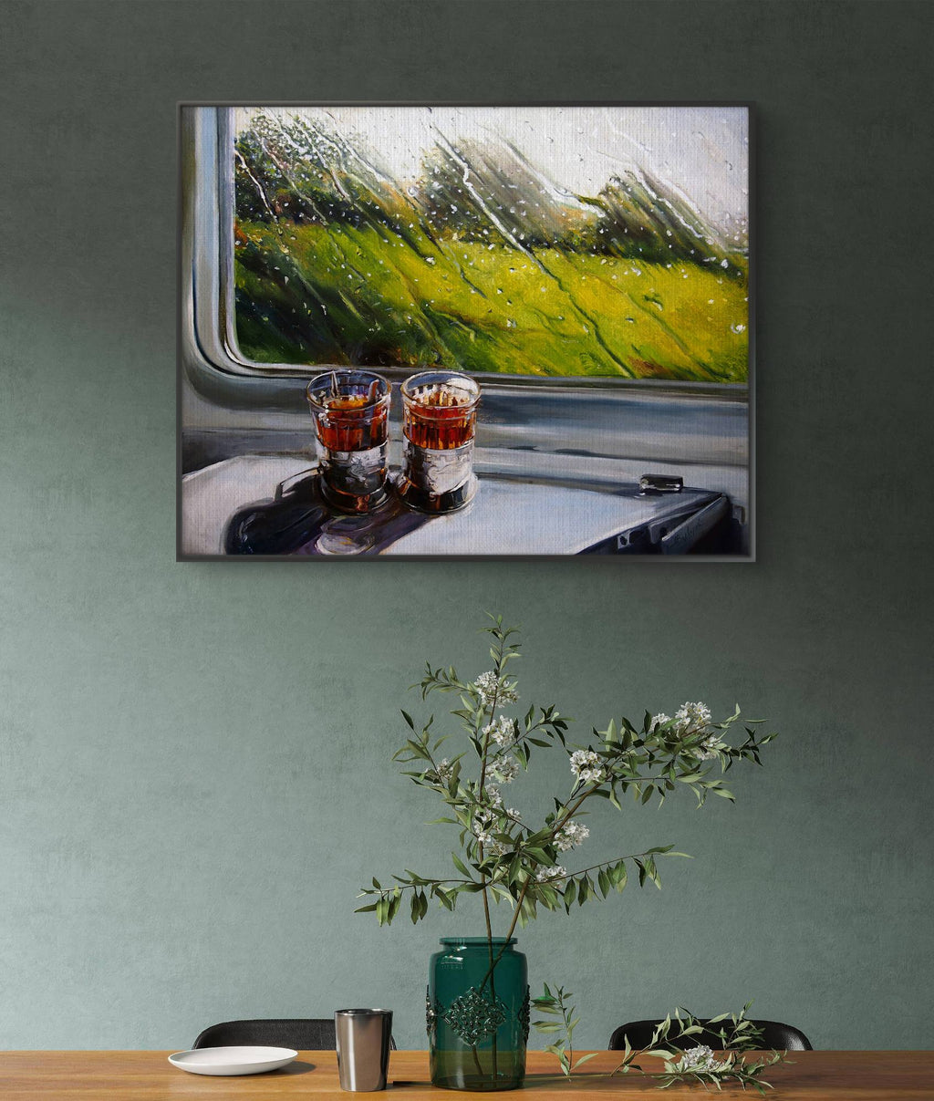 Framed painting of two glasses on a train window with a scenic view.