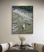 Framed abstract painting on a wall above a dining table with place settings.