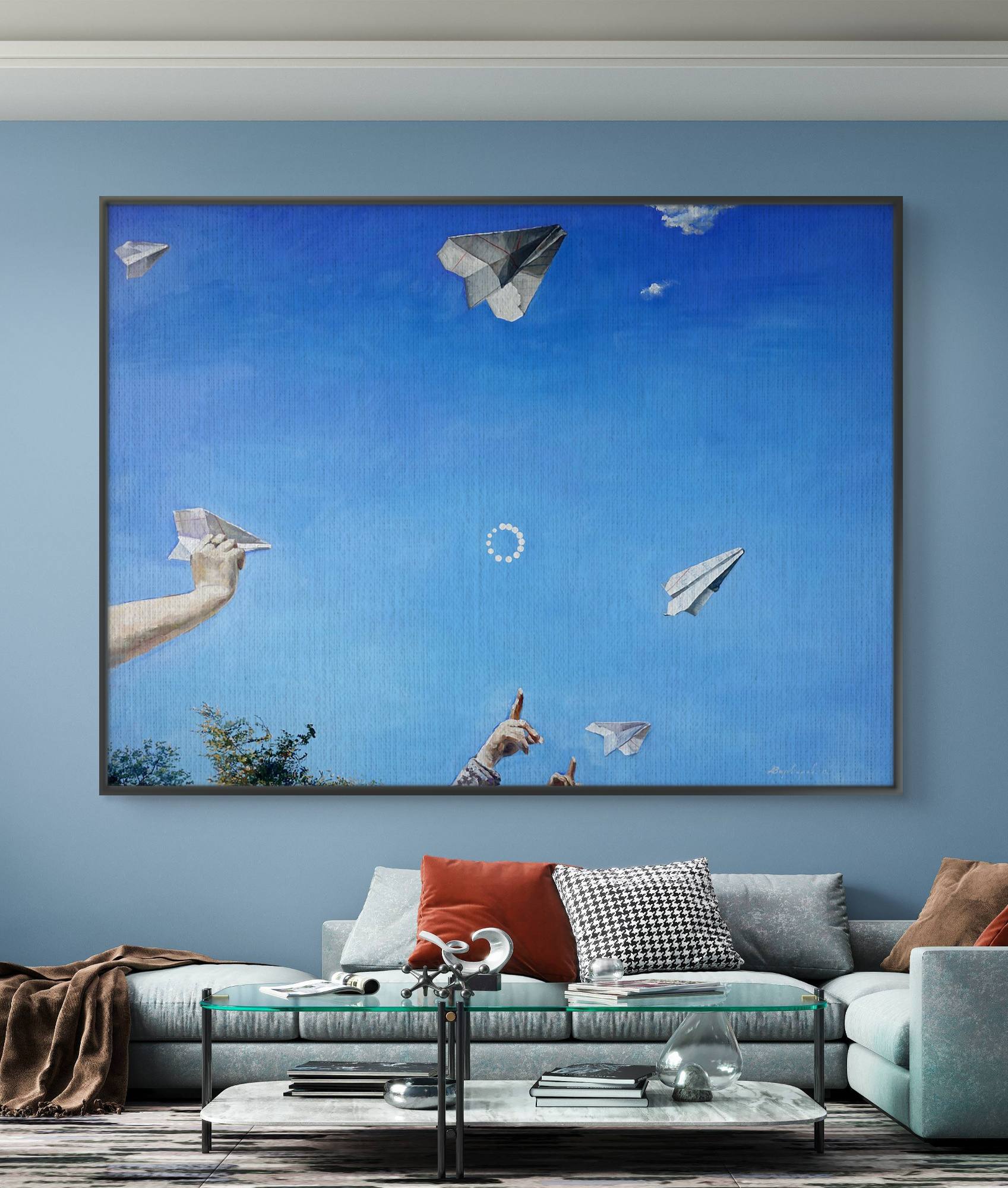 Framed artwork of paper airplanes in a living room with a blue wall.