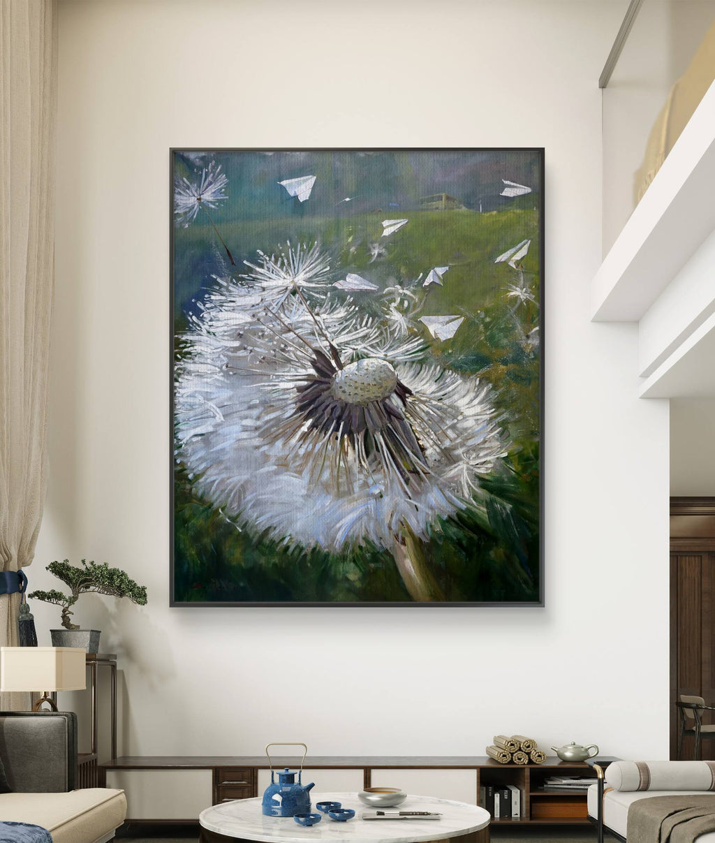 Framed artwork of a dandelion with seeds blowing in the wind, hanging on a wall in a living room.