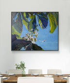 Framed artwork of leaves and flowers on a wall above a dining table.