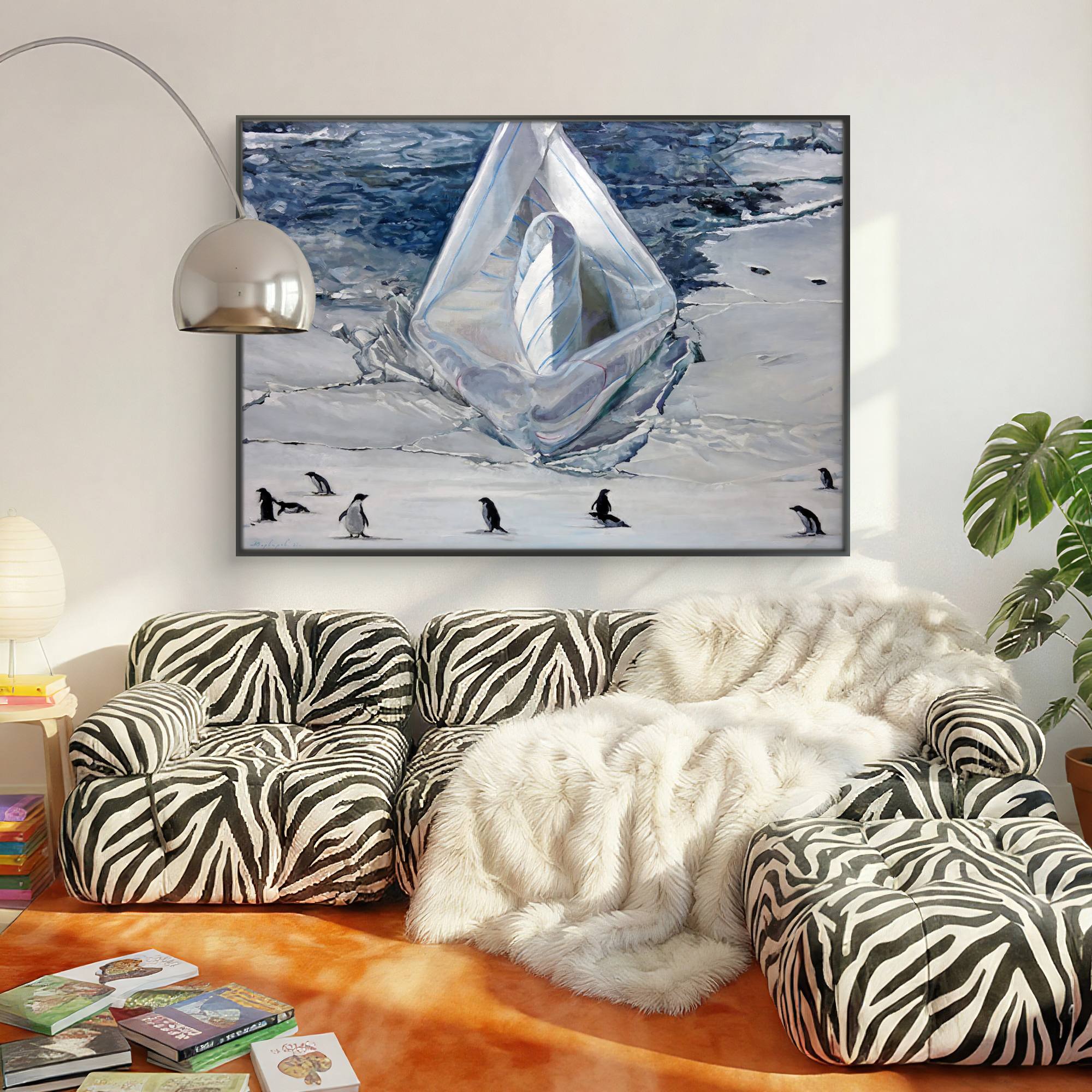 Living room with zebra-patterned sofa, white fur throw, and framed picture of ice and penguins.