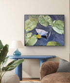 Framed artwork of a boat on water with lily pads in a living room setting.