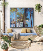Outdoor living space with a blue sofa, wicker chairs, and a large wall art piece of trees and a building.