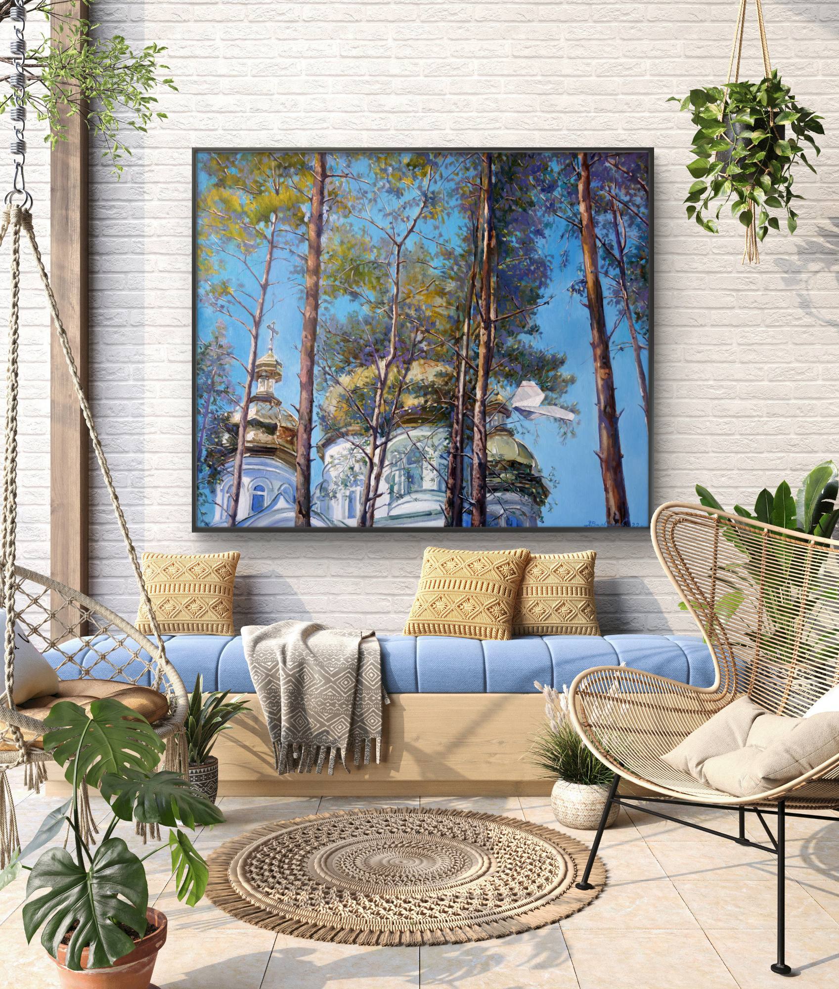 Outdoor living space with a blue sofa, wicker chairs, and a large wall art piece of trees and a building.