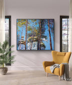 Yellow armchair in a room with a large painting of trees and a building on the wall.