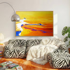 Living room with zebra-patterned sofa, abstract painting, and books on a wooden floor.