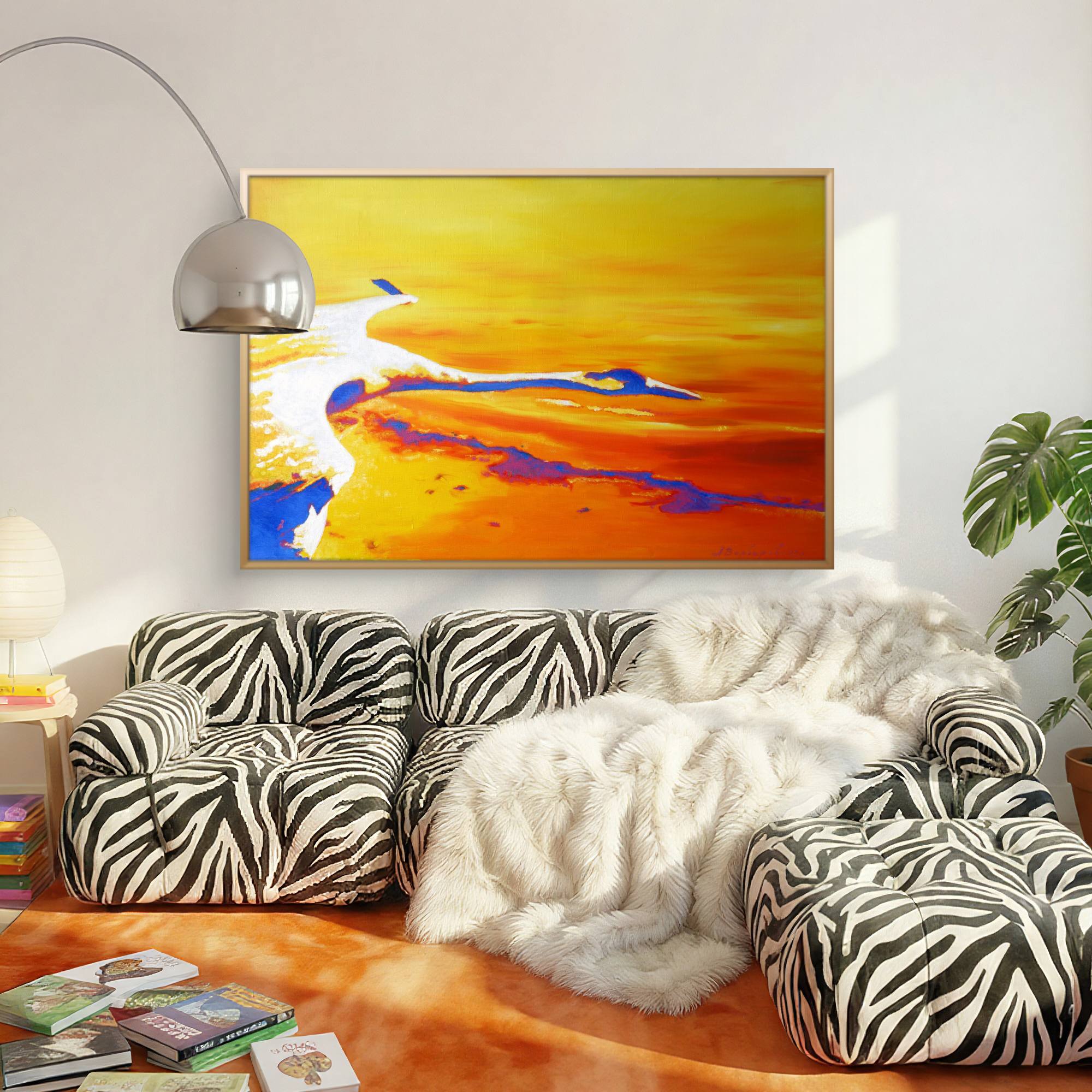 Living room with zebra-patterned sofa, abstract painting, and books on a wooden floor.