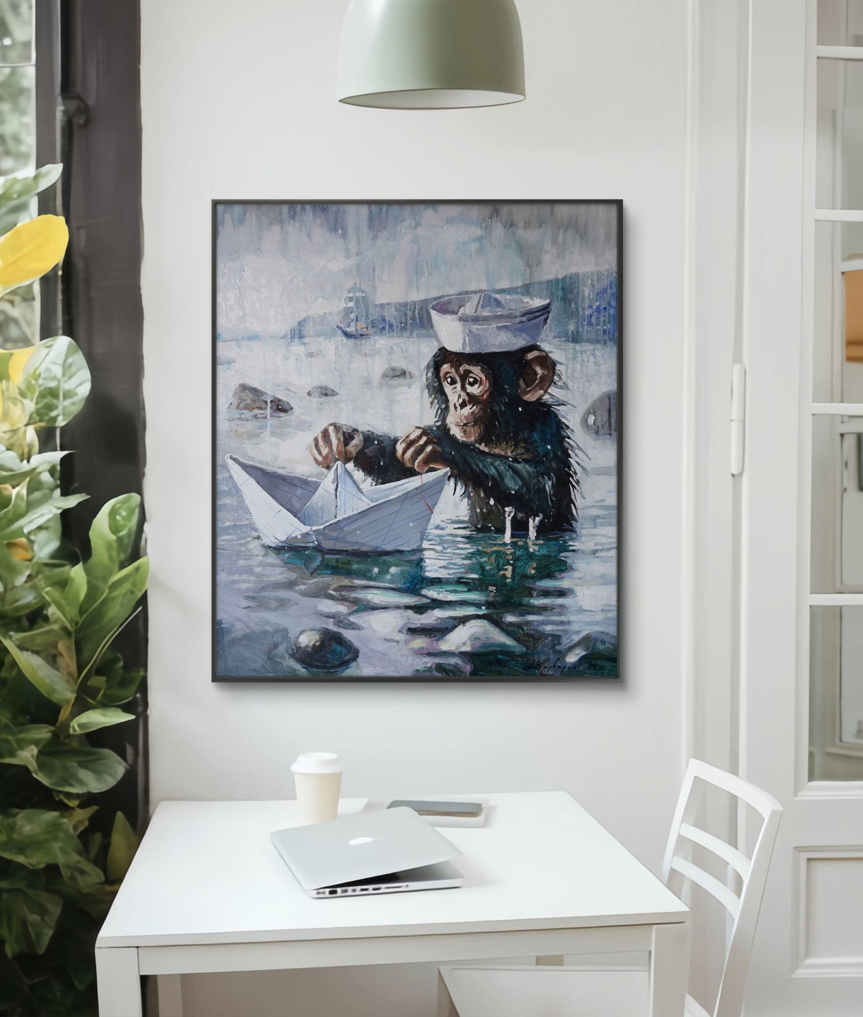 Framed artwork of a chimpanzee in a sailor hat with a paper boat on a wall above a white desk.