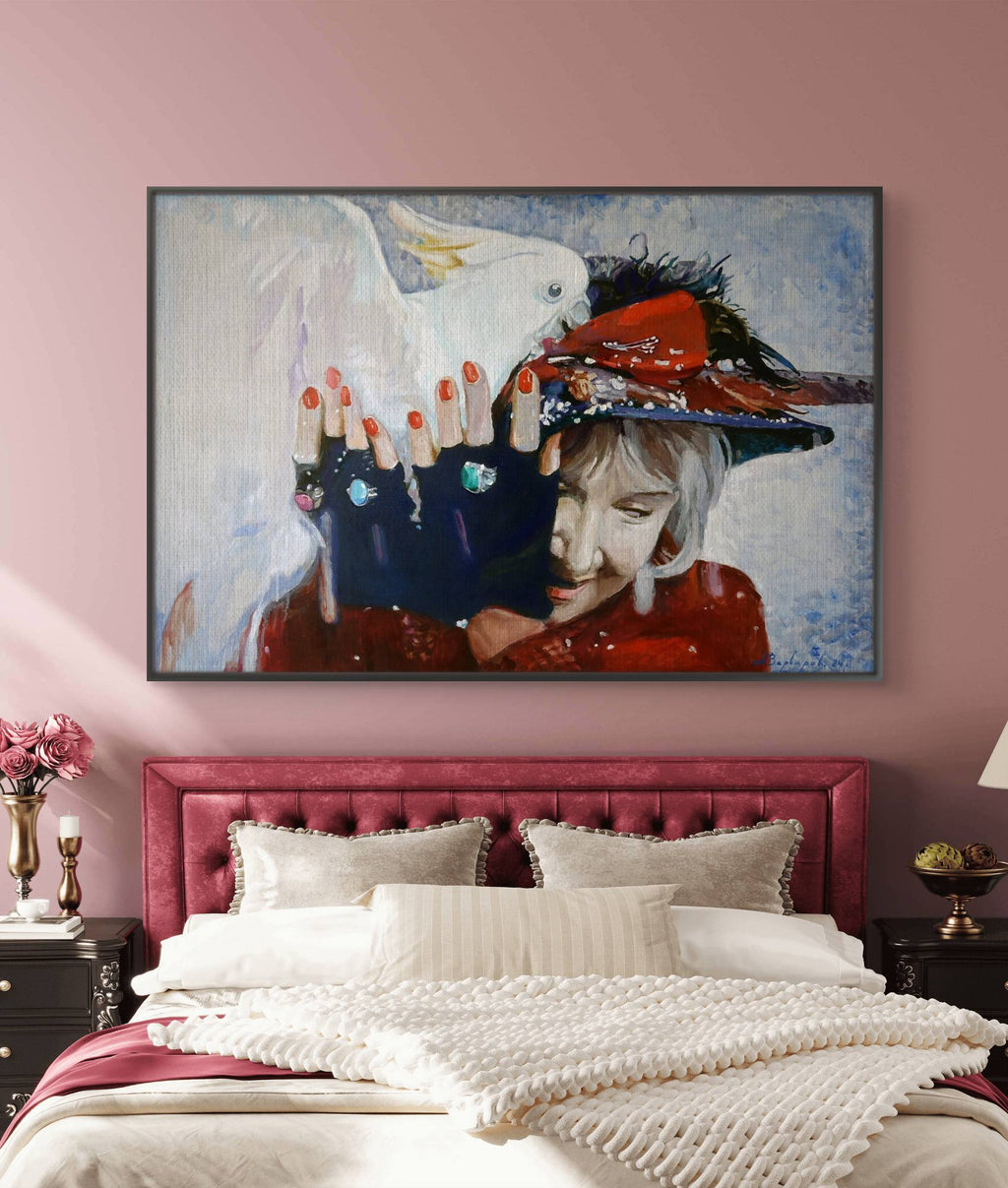 Framed artwork above a bed with pink headboard