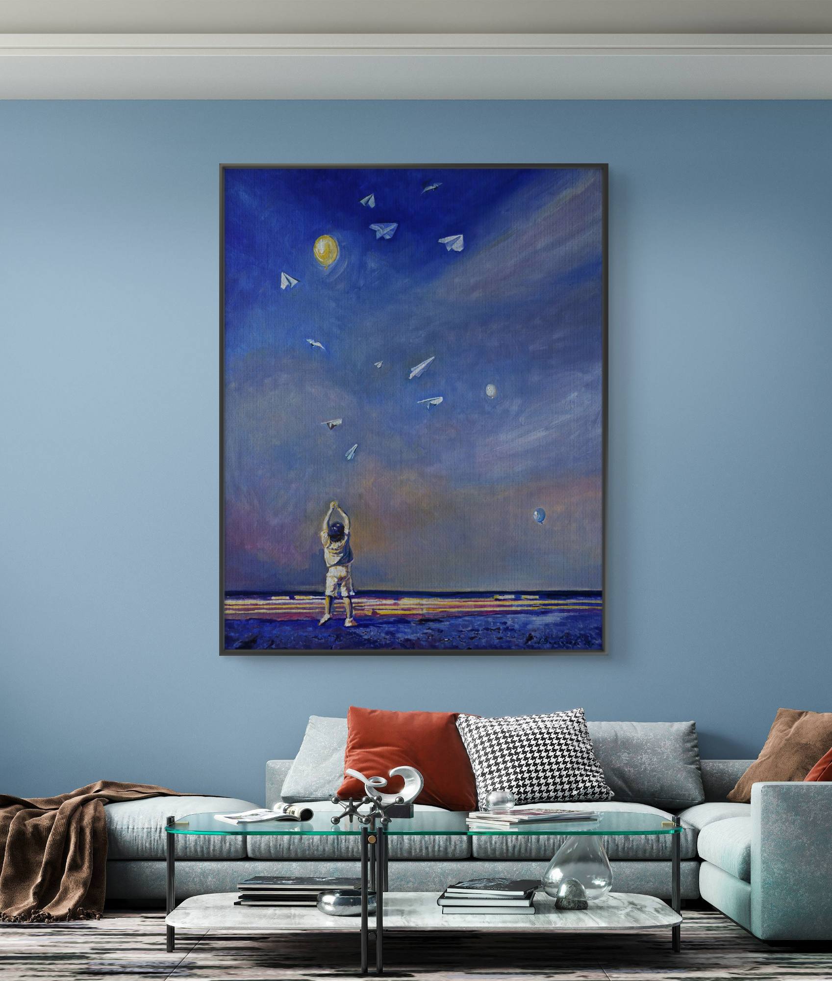 Framed artwork of a child looking at stars on a blue wall above a sofa.