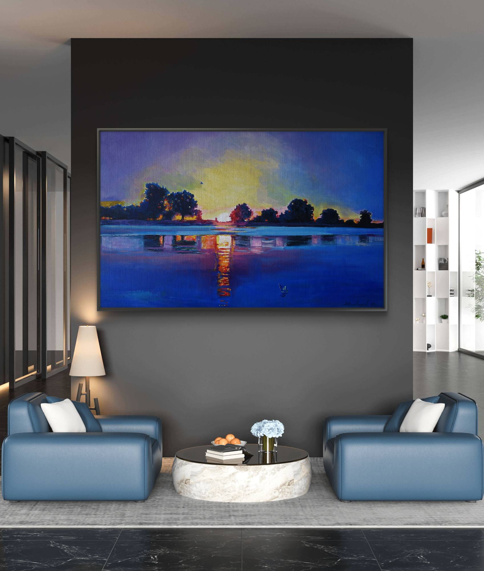 Modern living room with blue sofas and a large painting of a sunset over water.
