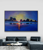 Framed artwork of a sunset over water on a wall above a sofa.