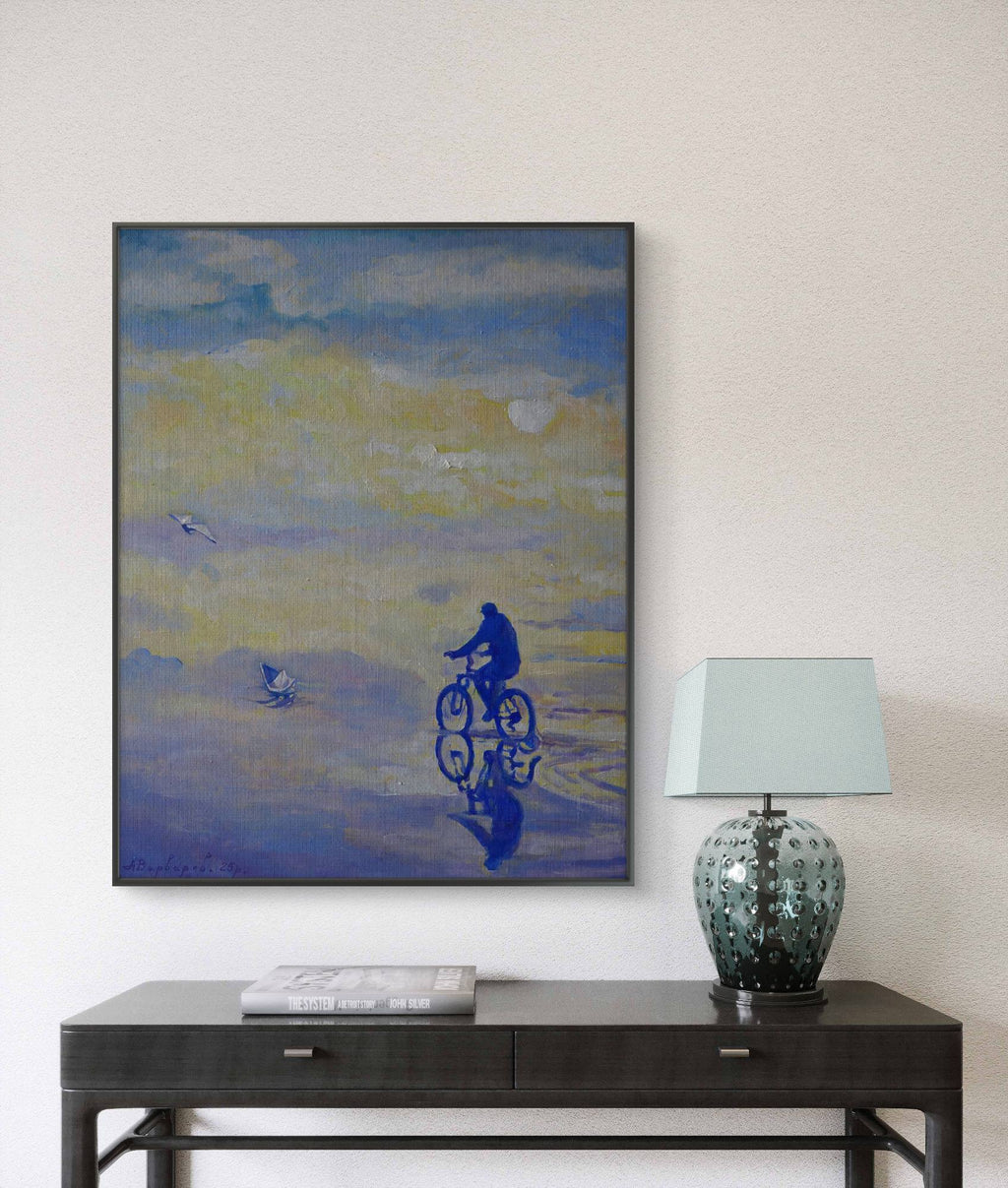 Framed abstract artwork on a wall above a table with a lamp.