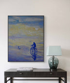 Framed abstract artwork on a wall above a table with a lamp.