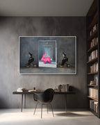 Modern interior with a framed artwork on a gray wall, a desk, and bookshelves.